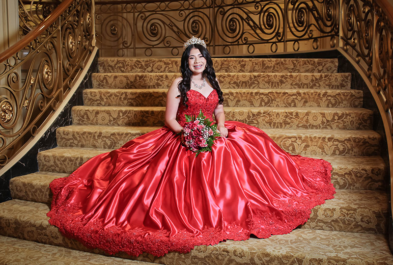 QUINCEAÑERA at The Westgate Hotel, girl sitting on staircase with ballgown and flowers