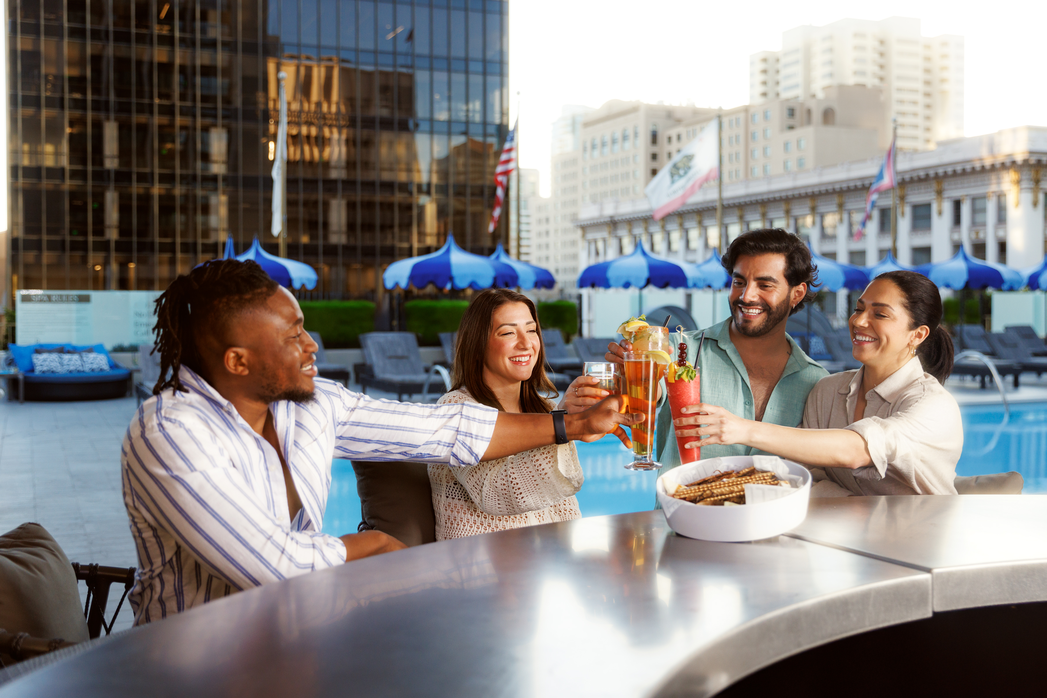 four friends cheers drinks at aquavie rooftop bar